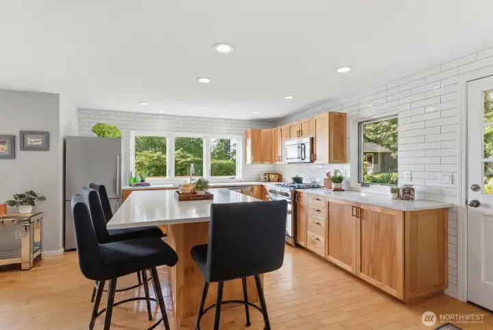 Maple hardwood floors and quartz countertops highlight the kitchen Maple hardwood floors and quartz countertops highlight the kitchen