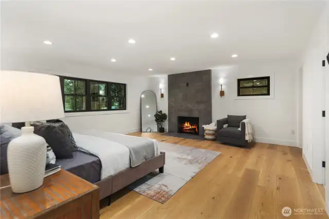The Primary suite, and oh how sweet it is...this huge space offers plenty of room for a King sized bed while also still allowing room for a seating area next to your own private and cozy wood burning fireplace, perfect for our PNW rainy nights. Nicely sized walk in custom closet complete with built-ins and drawers. The attached 3/4 bath is stunning.