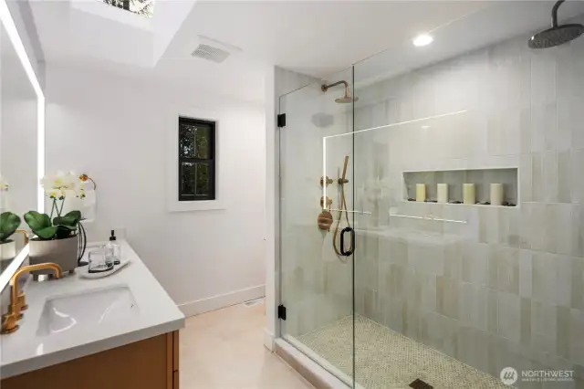 The showstopper of the primary suite is the spa-like bathroom...this spacious  walk-in shower with dual shower heads and stunning designer tile is all you need to wake up refreshed! Dual vanity, LED light-up mirror and gorgeous reeded tile flooring makes this primary bathroom the most sought after space in the house.