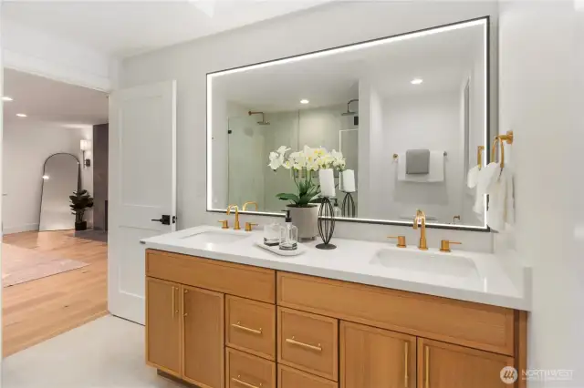 Integrated LED mirror light brightens up this primary bathroom suite and makes getting ready a breeze! The dual vanity is custom built for the space and offers tons of storage and designer look.