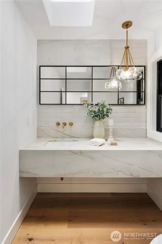 This powder room does not disappoint. From the slab floating quartz vanity to the designer tile wall...nothing was spared when it came to making this a show stopping space. Wide plank oak floors and tons of natural light.