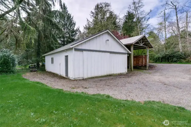864 sq ft shop with sliding front doors and wooden RV storage structure.