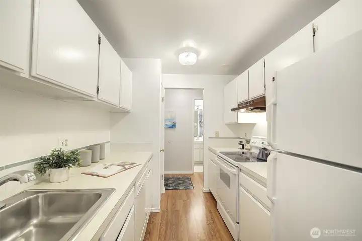 This view of the kitchen shows that the bathroom is just across the hallway, convenient for whoever is cooking dinner, but off the beaten path for privacy when you have guests.