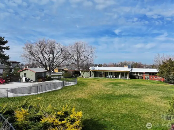 View of the back yard with shop & in-ground pool