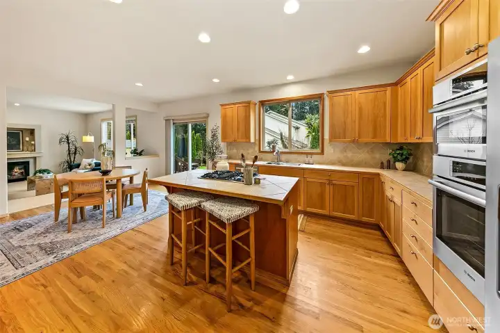 Well-appointed kitchen anchored by quality appliances including Bosch 800 Series oven and speed microwave, Amana gas cooktop, and Samsung dishwasher.