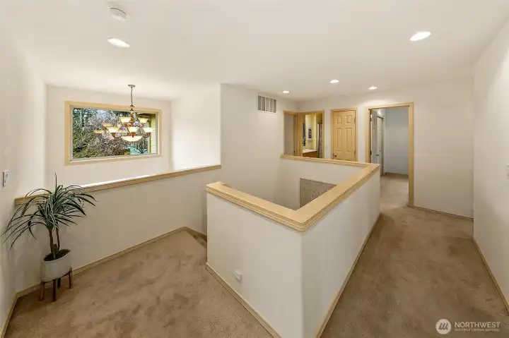 Upper-level landing connects bedrooms and flexible spaces with separation from the main living areas.