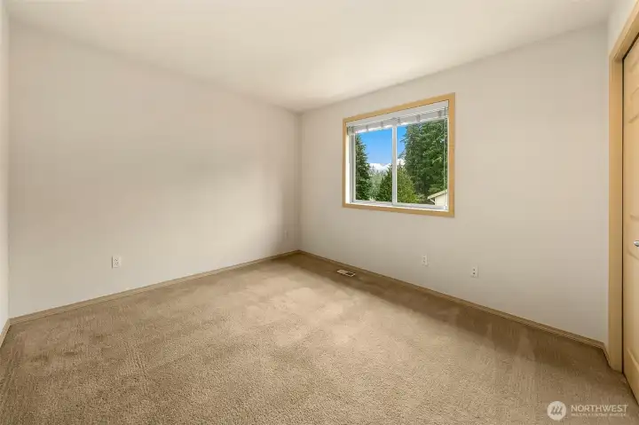 Bedroom with backyard outlook, previewing the expansive, professionally landscaped outdoor space.