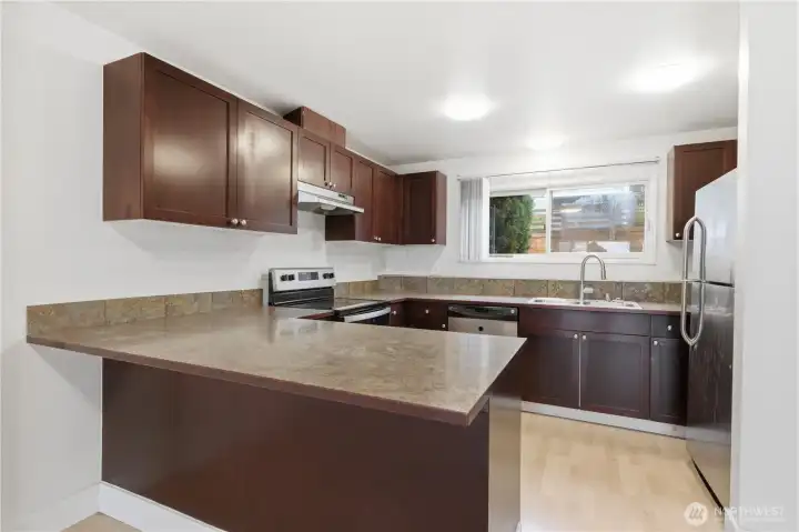 The open-style kitchen, adorned with rich-colored cabinetry & gleaming stainless-steel appliances, is perfectly situated for both practicality & style.