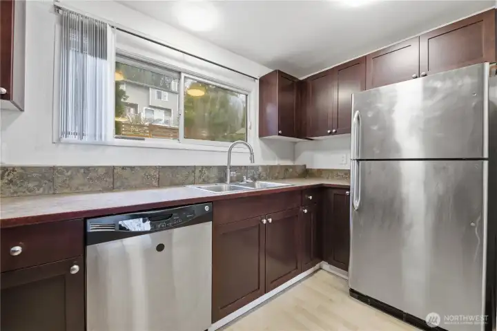 Kitchen boasts plenty of cabinet and counter space with expansive window above the sink that pours in natural light.