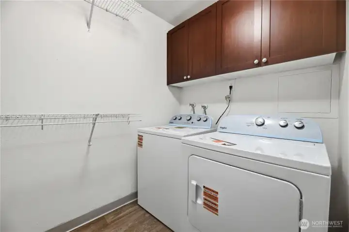 Downstairs laundry room with storage and hanging shelf.