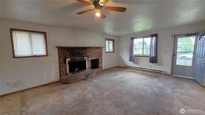 Spacious living room features a wood burning fireplace with wood box storage.  Conver to gas which is in the street.