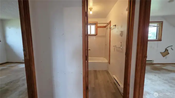 Hall opens to both bedrooms and bathroom