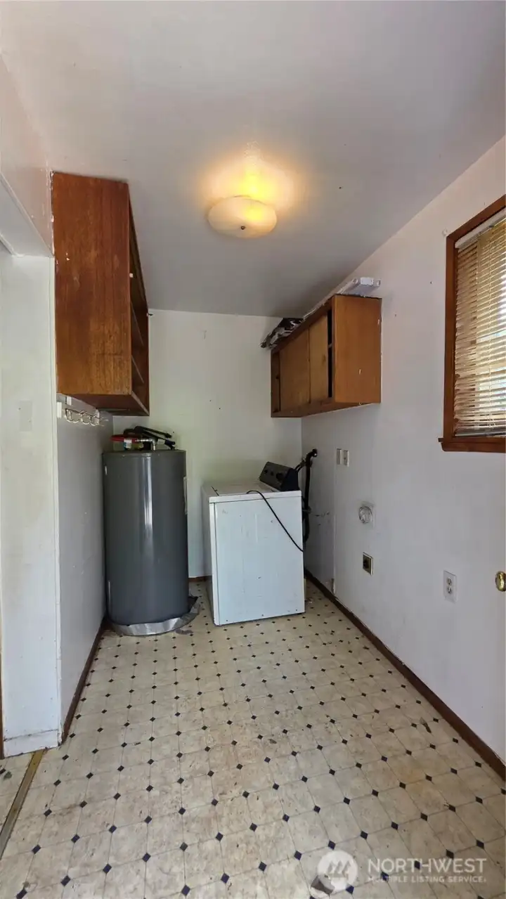Large laundry room is off the kitchen and also adjacent to the back bedroom for potential conversion to primary bath