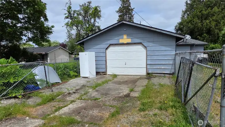 Alley access to the garage with additional parking - also fully fenced.  Gates are closed in 2nd photo.