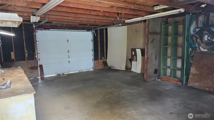 Garage has single door, work bench, storage cabinets + man-door to back yard and patio