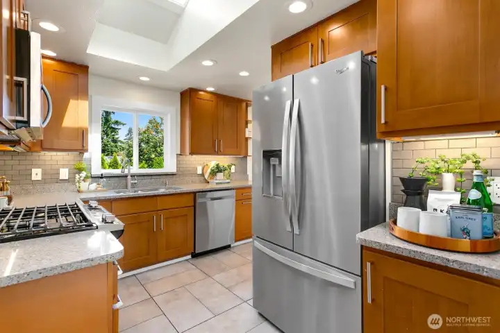 This kitchen with a huge skylight almost never requires lights to be on. The window above the sink overlooks the deck and backyard.