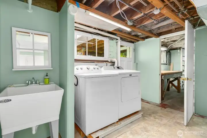 Laundry sits near the separate entrance to the lower level. There is also a workshop to the right in this photo. Or more storage!
