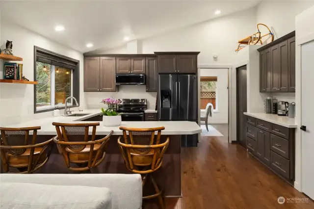 The gourmet kitchen has been meticulously renovated with top-of-the-line stainless steel appliances, quartz countertops, and new cabinets.