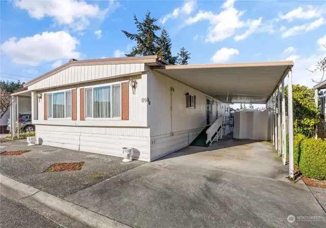 Carport side of home with ramp and back porch.  The divider is moveable so you can make your parking larger or your private patio larger