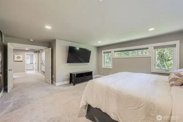 Oversized primary suite with green views and dramatic entryway.