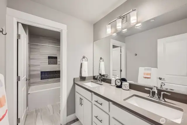 2nd Story Full Bath with quartz counters and built-in accent tile shelves in shower.