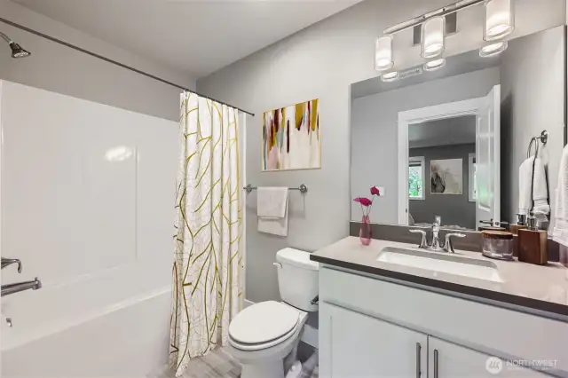 Full bath with shower-tub combo and quartz counters on lower level.