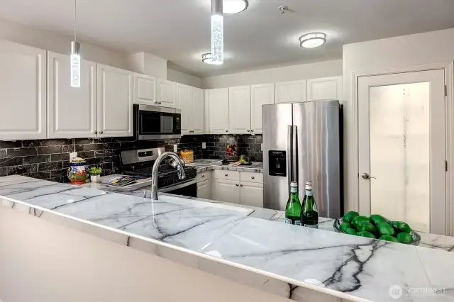 The heart of the home is the updated kitchen, complete with a brand-new gas stove, walk-in pantry, and a convenient eat-in bar.