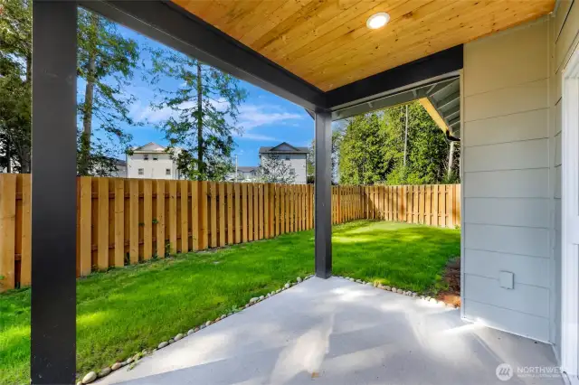 covered back patio and fenced backyard