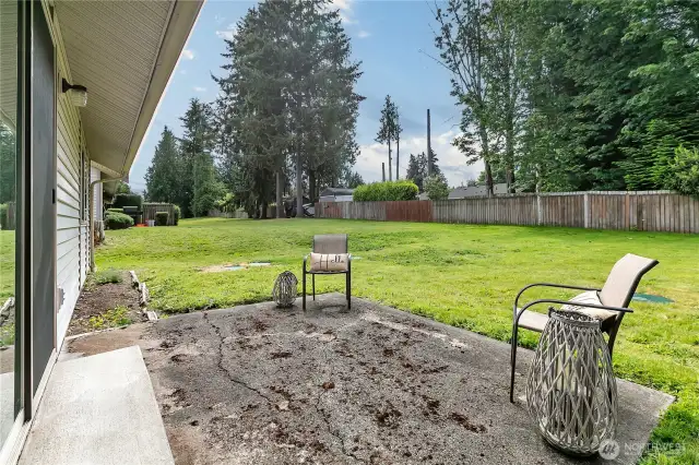 Back patio and partially fenced yard.