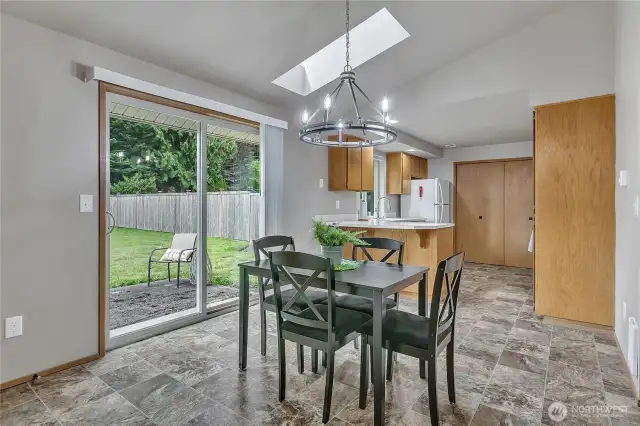 A skylight in the dining room adds natural light, while a slider leads to the partially fenced backyard.