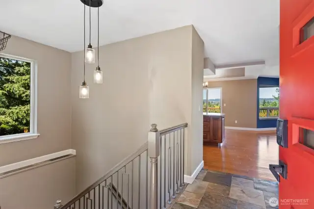 Entryway offers access to both the lower level and main living spaces. Contemporary lighting and staircase updates elevate the space.
