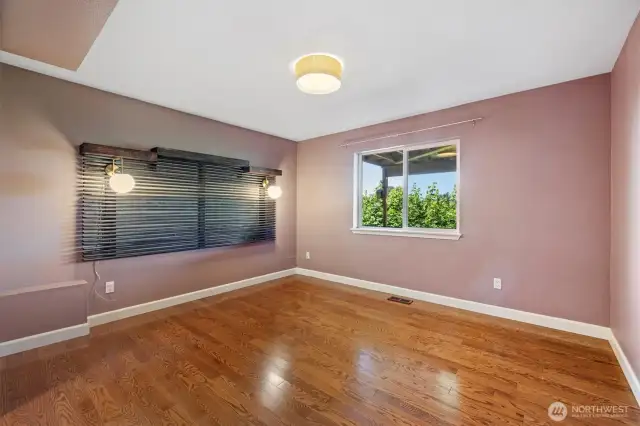 Lower-level bedroom with stunning hardwood flooring and modern light fixtures.