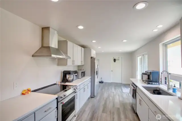 Galley kitchen leads to laundry room w/ half bath and garage
