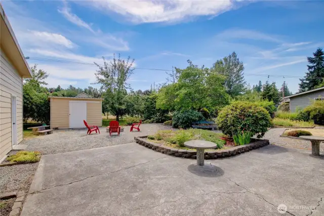 Back of home with private pathways through mature landscape.