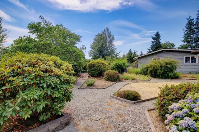 Back of home with private pathways through mature landscape.