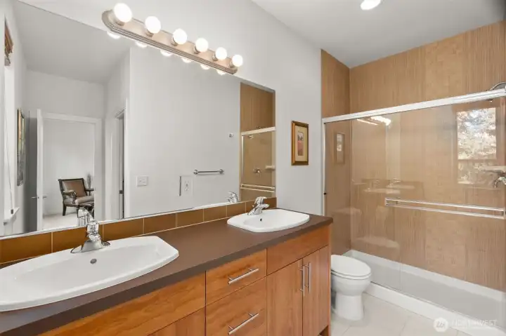 Lower level bath with double vanity and walk in, low barrier shower. Beautiful tile accents in the fully tiles shower.