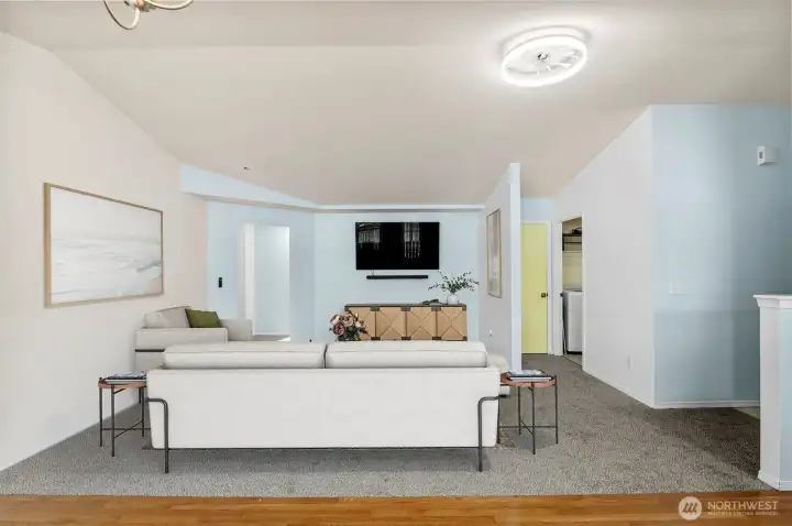 Bright open-concept living room with large windows and abundant natural light. (Virtually Staged)