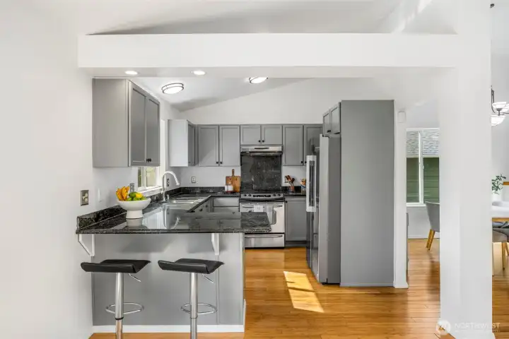 The kitchen offers ample storage, a breakfast bar with seating, and opens seamlessly to the dining area.