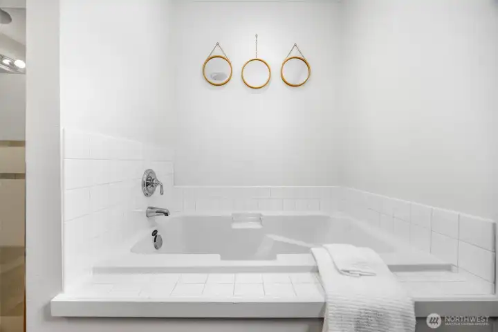 A generous soaking tub in the primary bathroom adds a relaxing, spa-like touch.