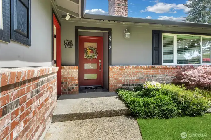 Rustic original brick, freshly painted front door, dramatic dark colored trim and clean lines greet your entrance!