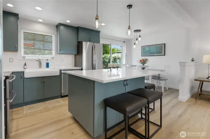 Farmhouse sink, flat panel cabinets, stainless steel appliances, crown molding and an abundance of lighting detail this modern kitchen!