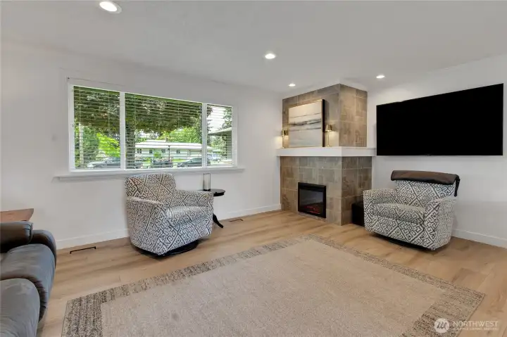 Tiled fireplace surround, wood mantel, ambient lighting and a sleek electric fireplace insert set the stage for a relaxing evening at home!
