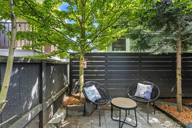 Backyard features a patio and an area for gardening and pots.