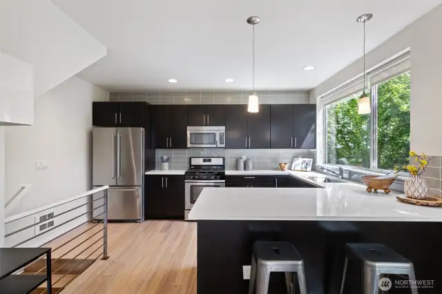 Stainless appliances, quartz counter tops and glass backsplash are the highlights in this kitchen.