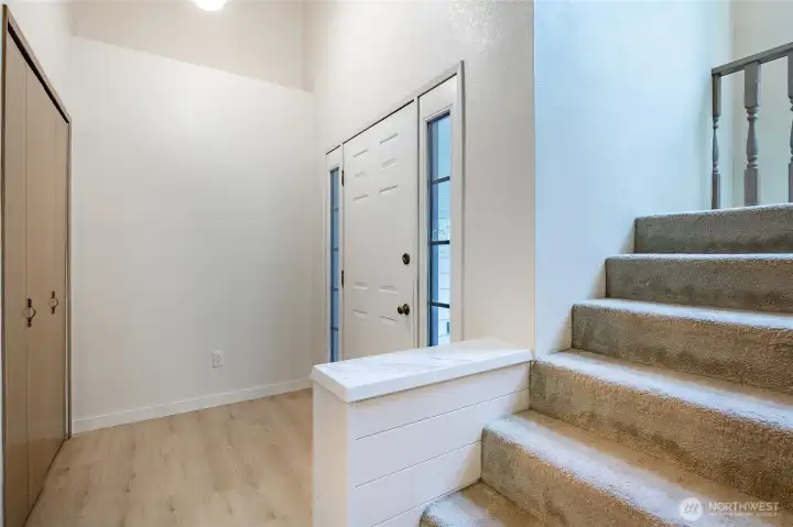 Clean, welcoming entry features new flooring, paint and lighting