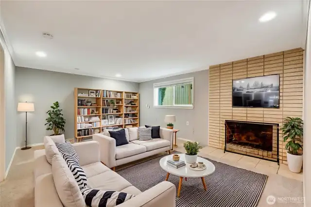 Lower level family room/bonus room / rec room/ livingroom with a fireplace (virtually staged)