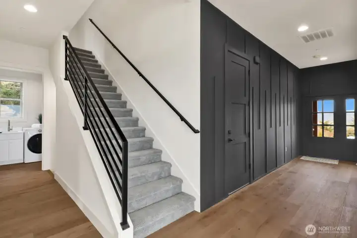 The front hall features a stunning art wall and a beautiful staircase to the upper level of the home