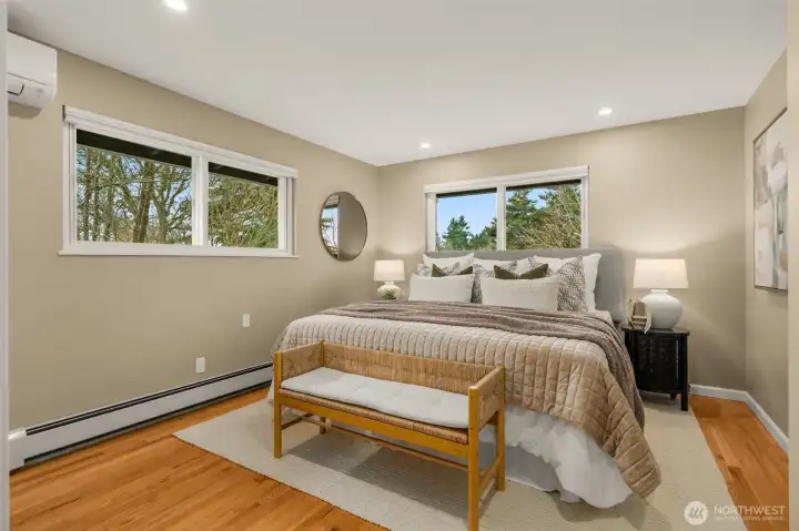 Primary Bedroom on Main easily accommodates a king bed plus side tables. Note the mini-split to help you sleep more comfortably during the hottest days of the year.