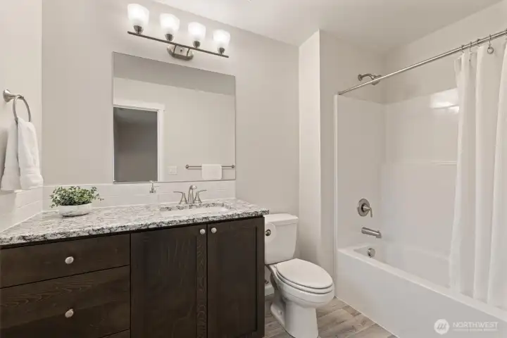 Primary Bedroom Ensuite Bath - featuring spacious vanity with storage, stone countertop, under-mount sink & tile backsplash.