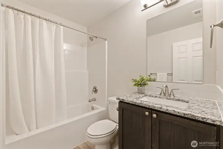 Full Bathroom off the hallway with upgraded stone countertop, under-mount sink & tile backsplash.